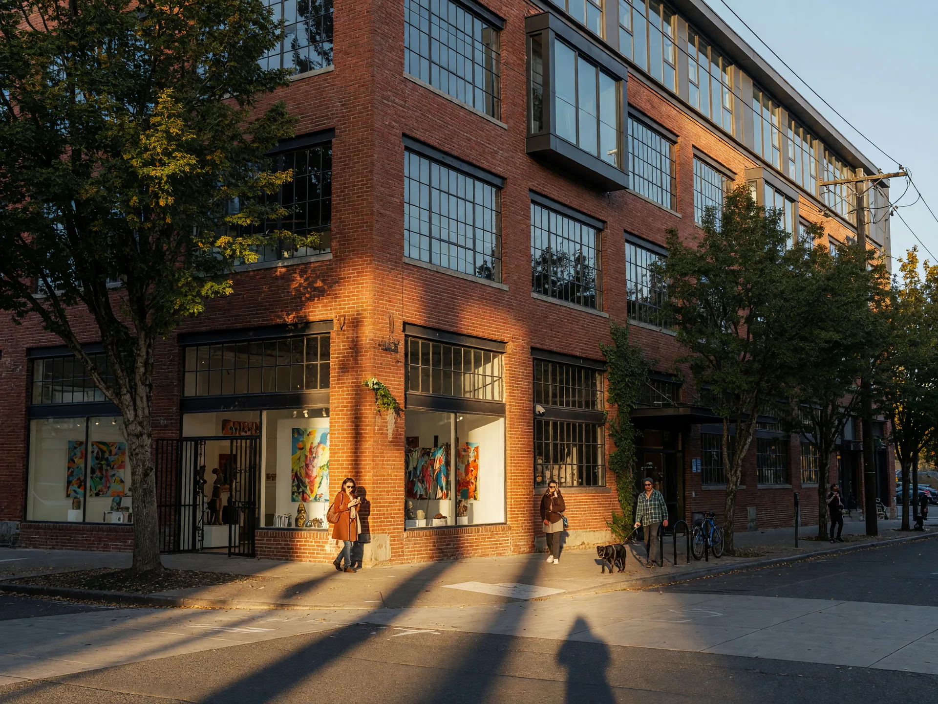 Converted brick warehouse lofts and gallery storefronts on a Pearl District street in late-afternoon light