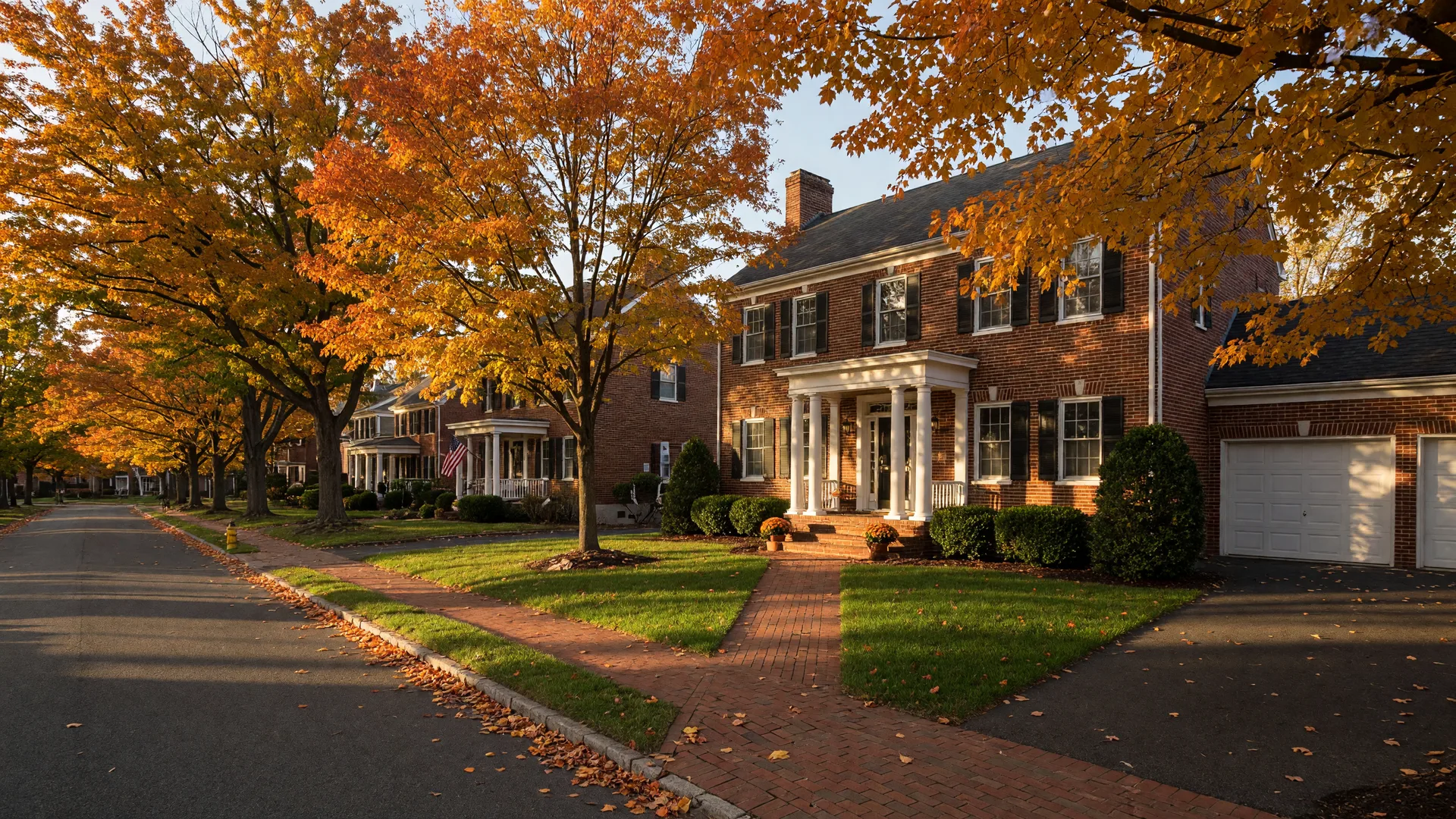 A classic brick colonial home on a maple-lined street in Howard County, Maryland in golden autumn light