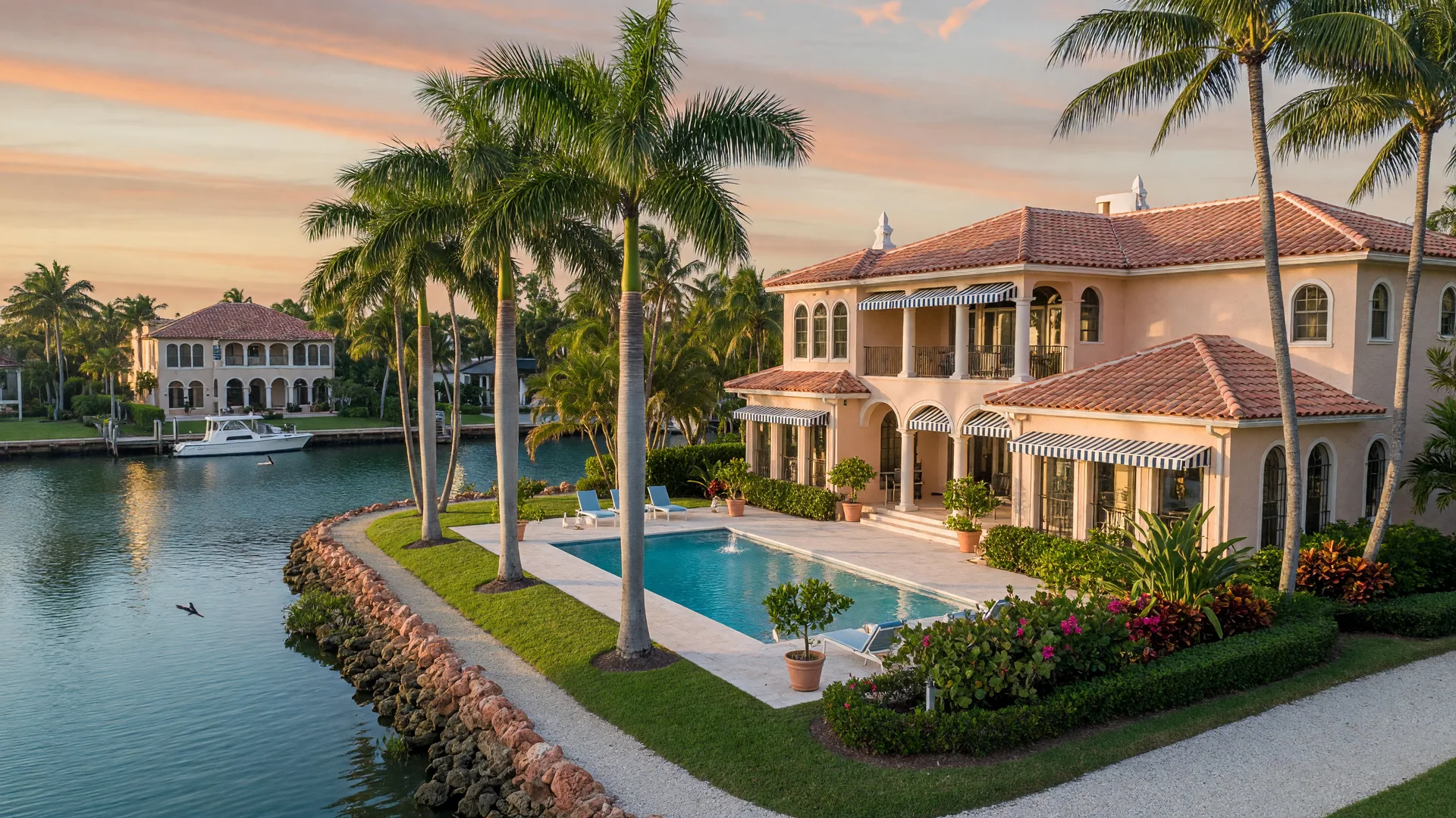 Waterfront home in South Florida with pool and palm trees during late afternoon light