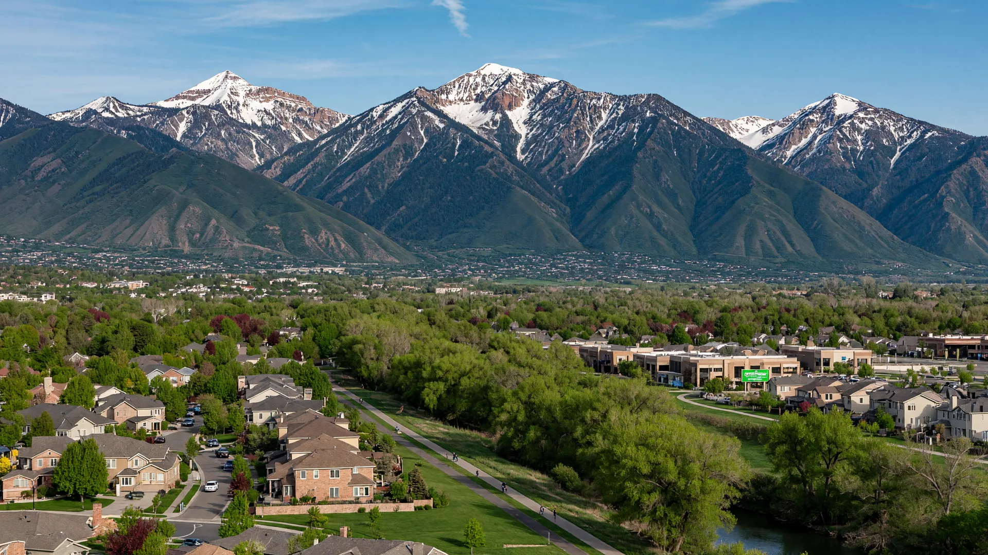 Sandy, Utah — the dramatic Wasatch Mountain range towering behind the South Towne area and Jordan River Parkway, mountain backdrop dominating the scene