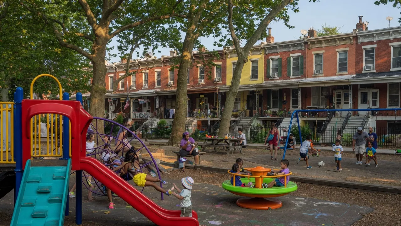Columbus Square playground in East Passyunk Philadelphia with families and children on a bright summer morning