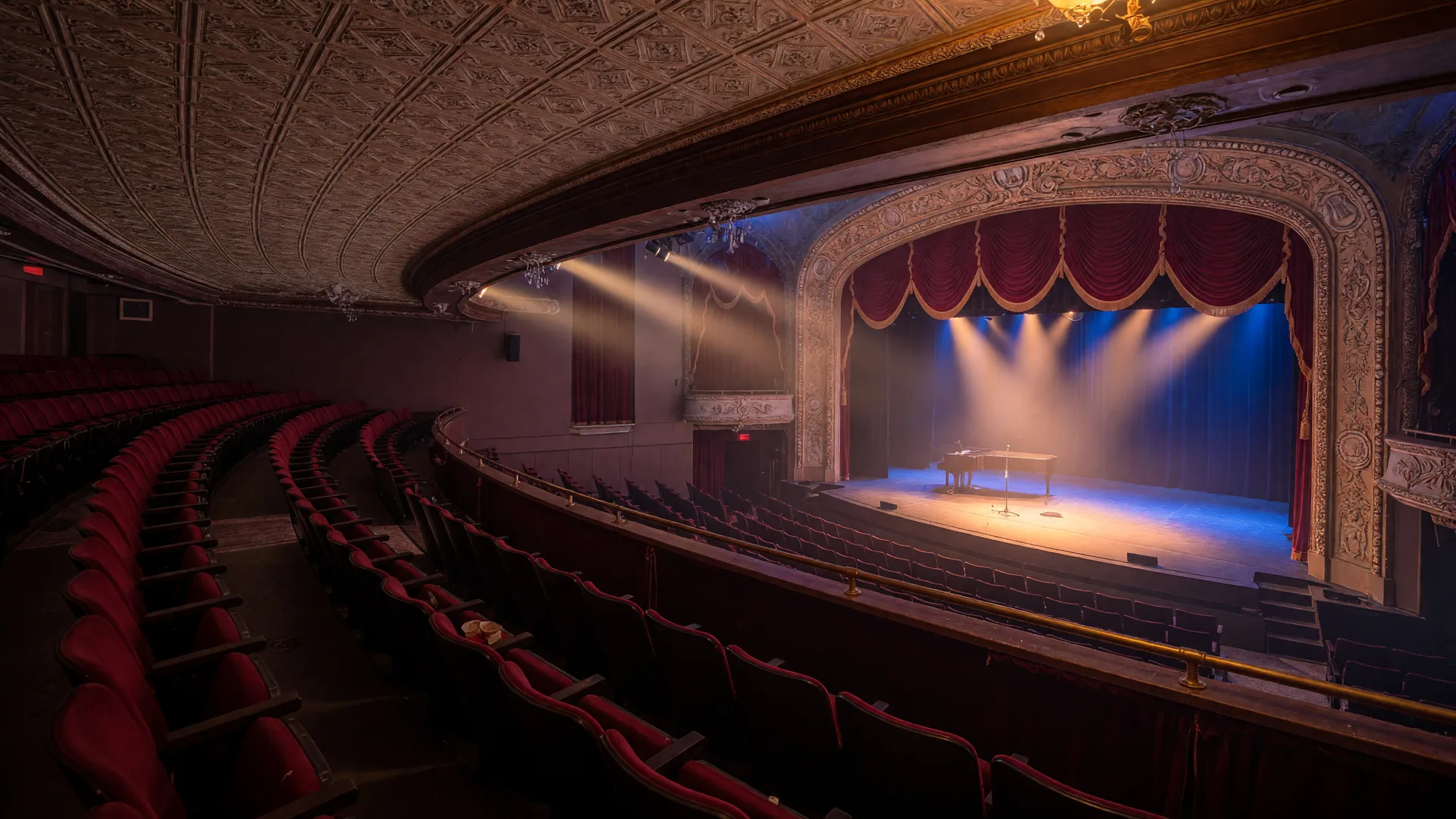 A historic concert hall stage washed with warm amber and blue stage lighting