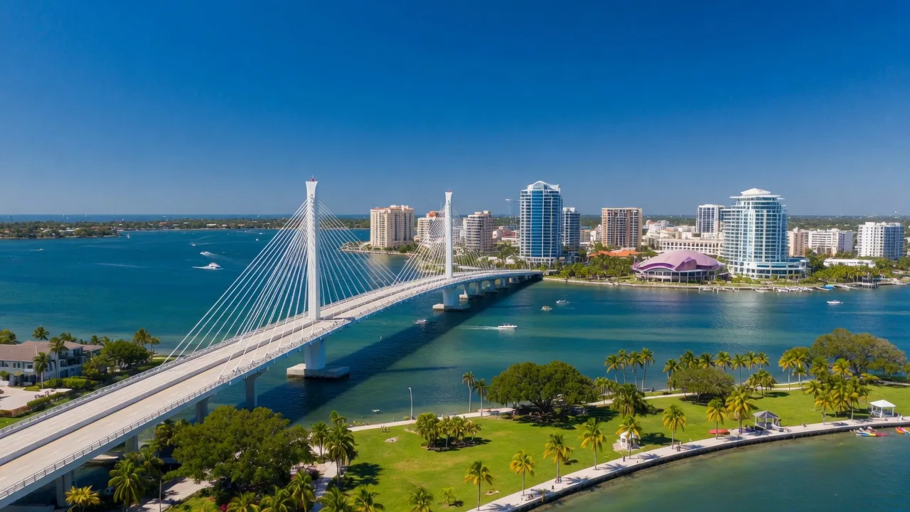 Authentic aerial view of downtown Sarasota, Florida with the John Ringling Causeway cable-stayed bridge spanning Sarasota Bay and the city skyline under bright Florida sunshine