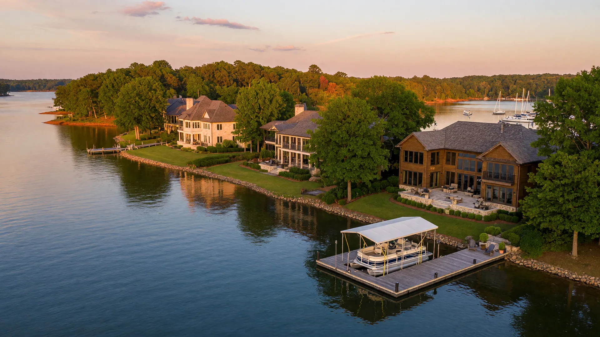 Golden hour aerial view of a Lake Norman luxury waterfront neighborhood with private docks and lakefront estates