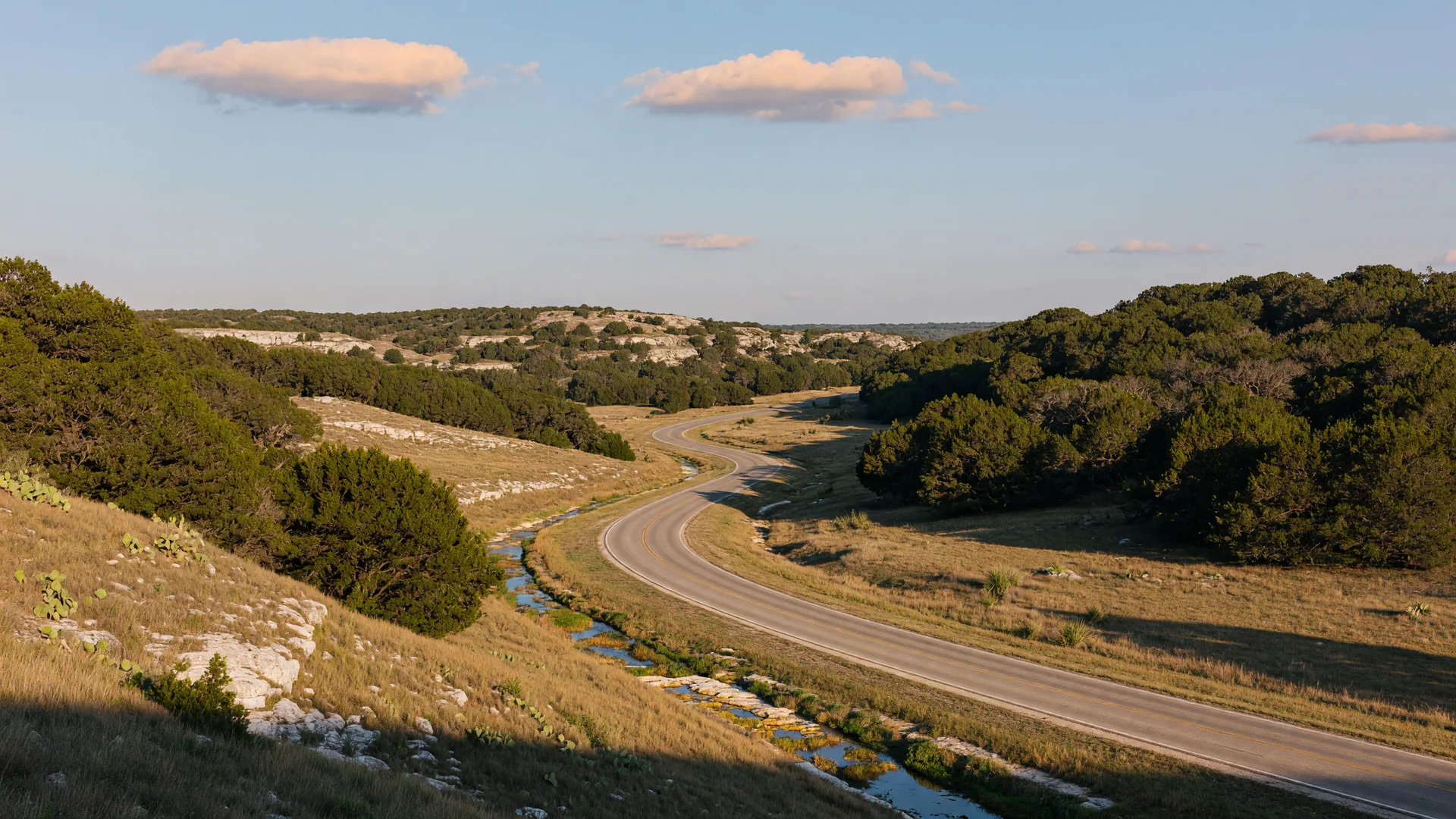 Rolling limestone hills and live oaks of the Texas Hill Country at golden hour