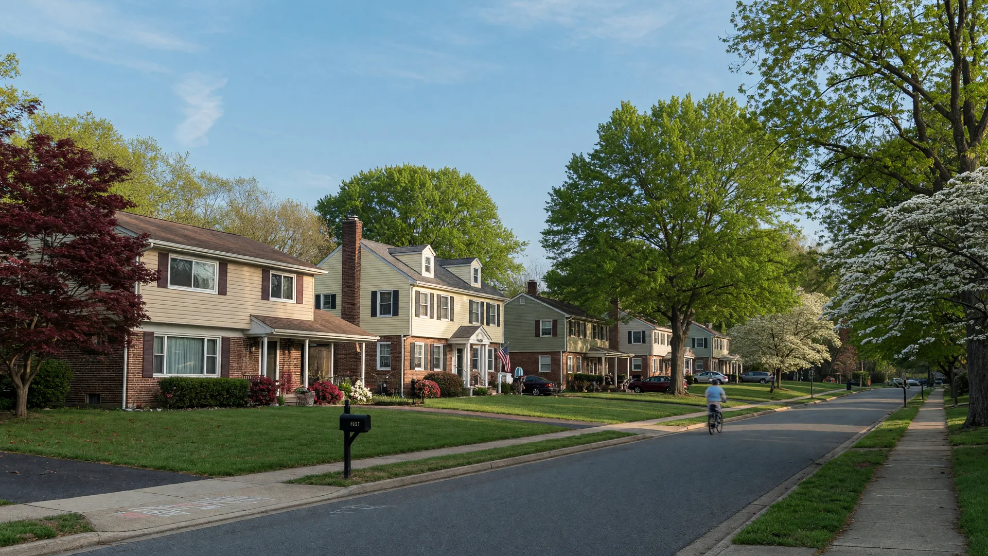 A leafy suburban street in Bowie, Maryland with 1960s split-level and colonial homes in morning light