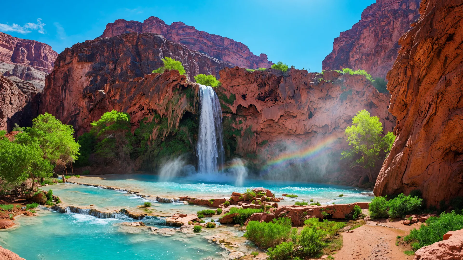 Havasu Falls in the Grand Canyon with turquoise water cascading over red sandstone into a clear pool
