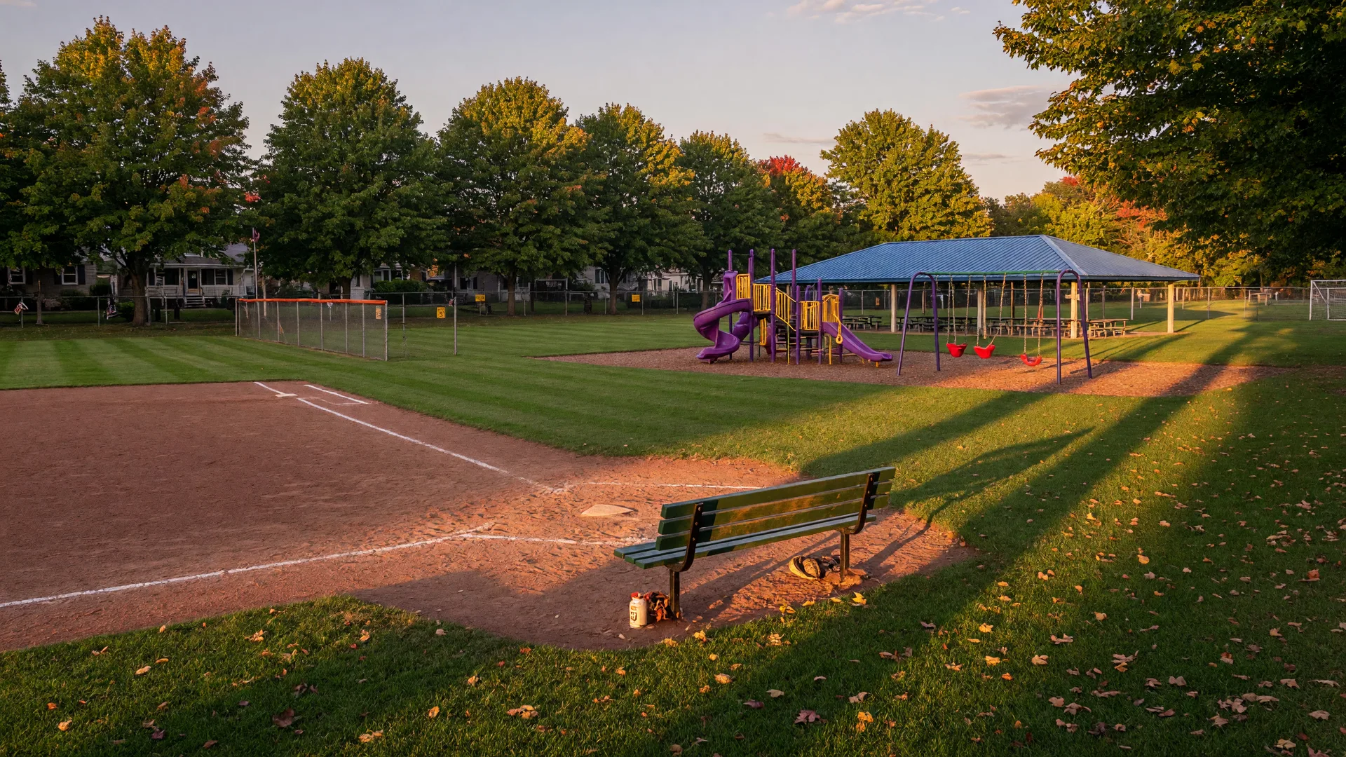 Neighborhood park in Folsom, Pennsylvania with a youth baseball diamond and playground in warm early September light