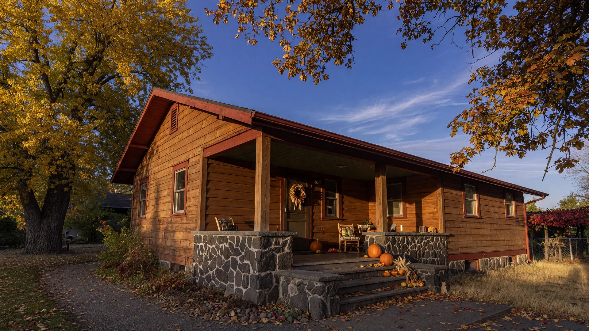 A craftsman home in the Tri-Cities with cedar siding and a stone-accent porch in warm autumn light, leaves just beginning to turn