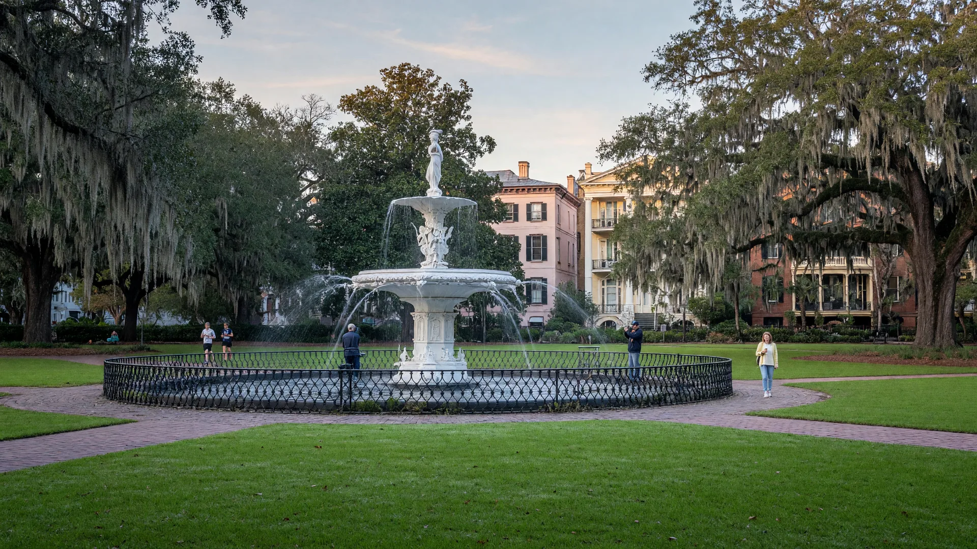 The white cast-iron fountain at Forsyth Park in Savannah, framed by live oaks