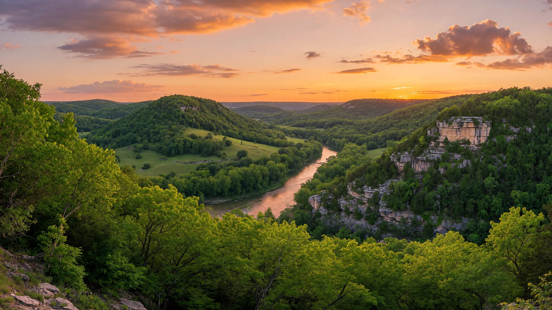 Scenic view of the Missouri Ozarks at golden hour with rolling green hills and limestone bluffs