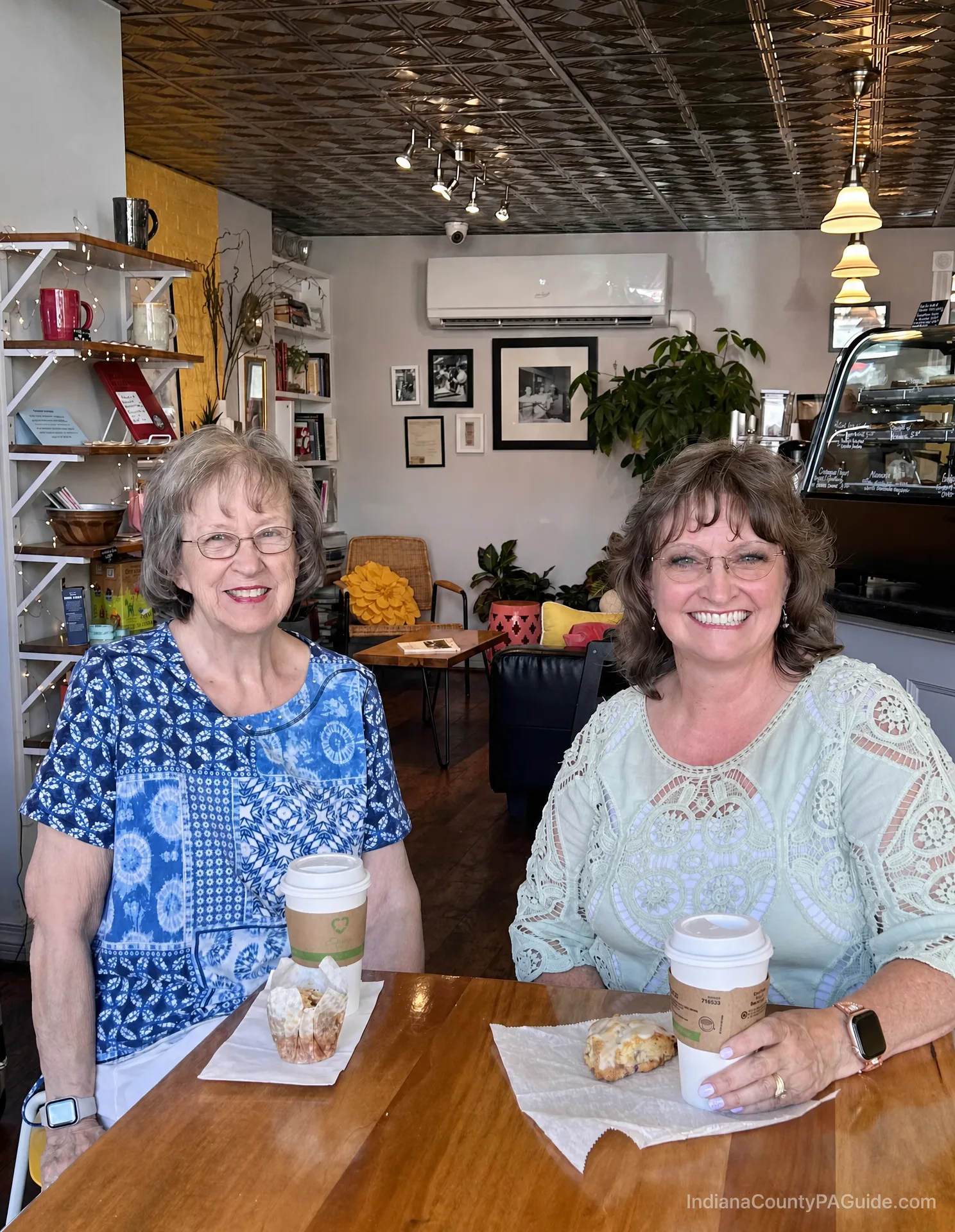 A cozy cafe table at Sit 'N Stay Cafe in Indiana, PA, with a muffin and scone