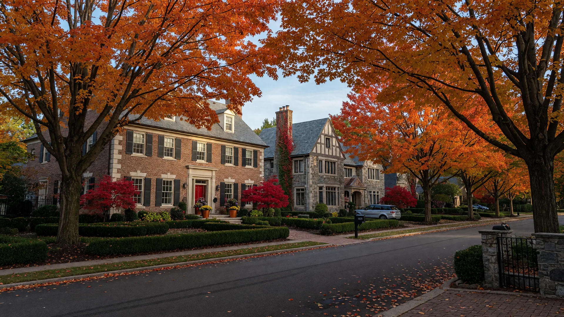 Upscale Westlake, Ohio residential street with brick and stone custom homes and mature maples at peak autumn color on a crisp October morning
