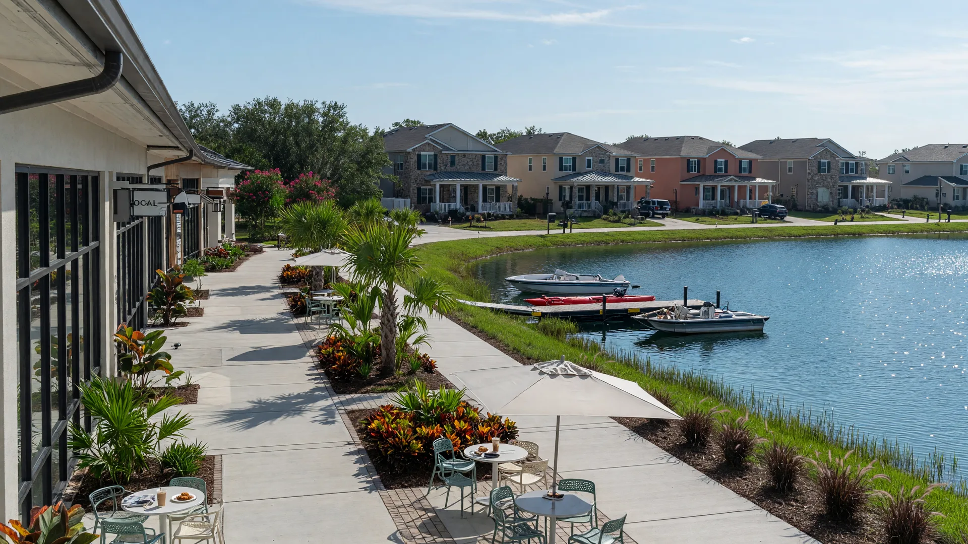 A lakefront town center in Horizon West with shops, cafe tables, and new homes behind the tree line.