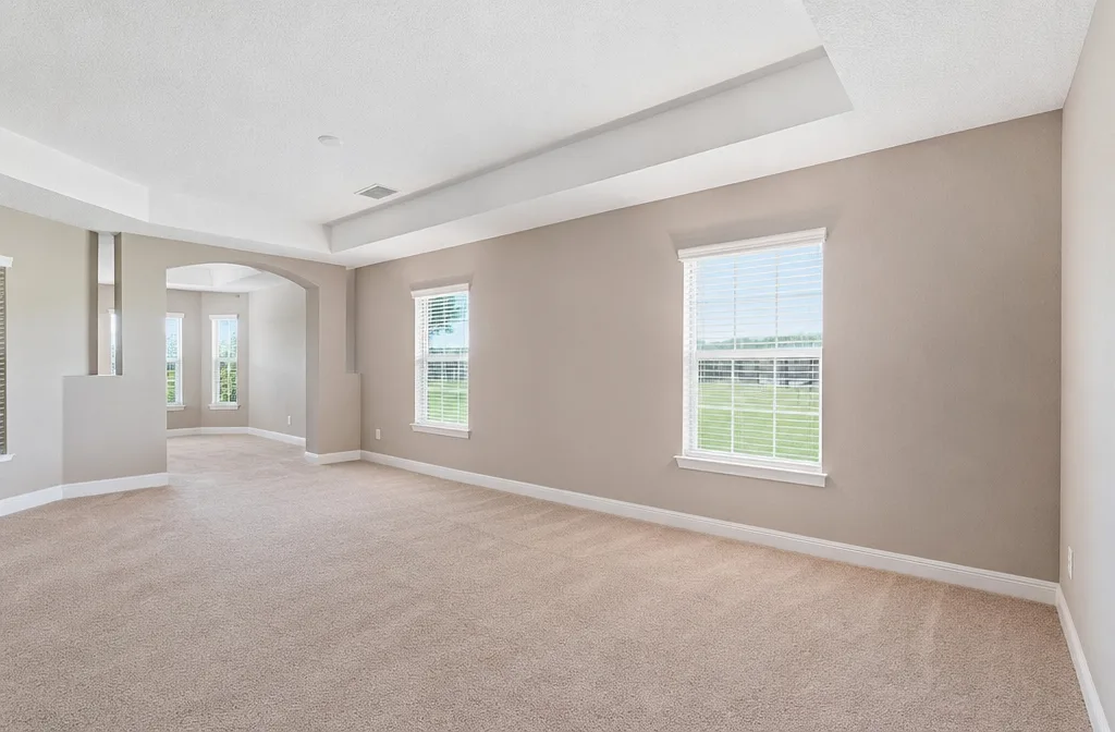 Primary bedroom suite with tray ceiling and natural light