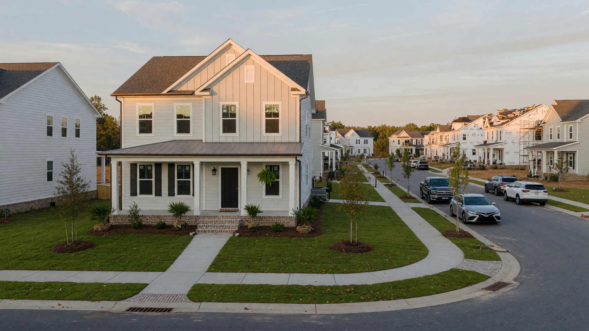 A brand-new two-story home with a front porch on a fresh lot in a Cane Bay-style master-planned community near Summerville, South Carolina, in late-afternoon light