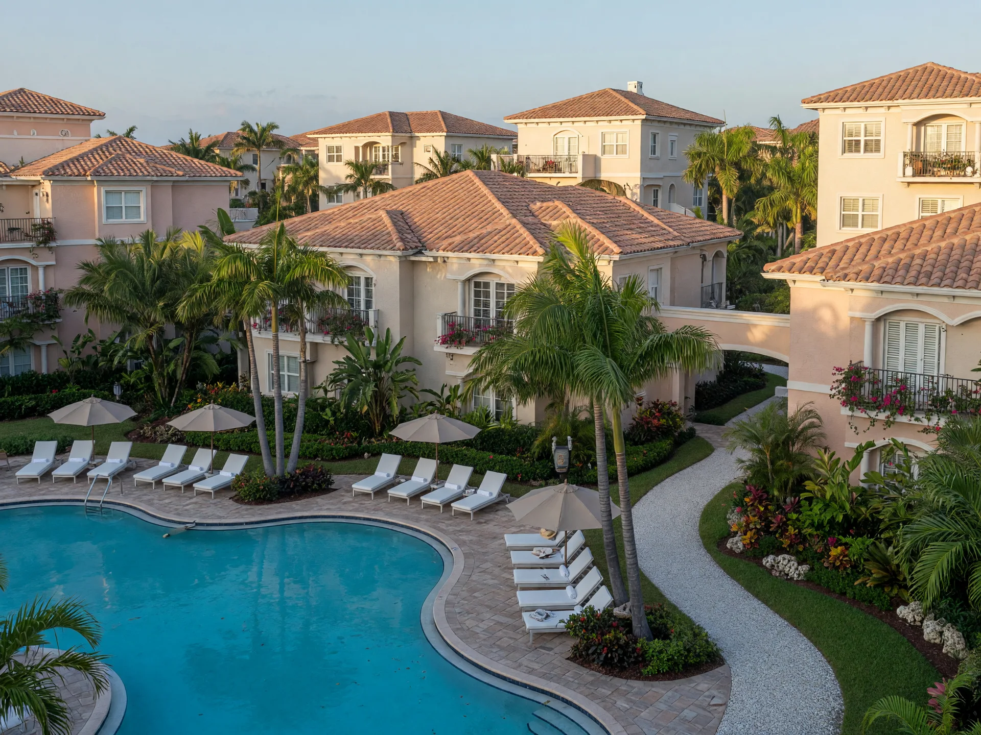 A modern villa and condominium community in Boca Raton with a resort-style pool and tropical landscaping.