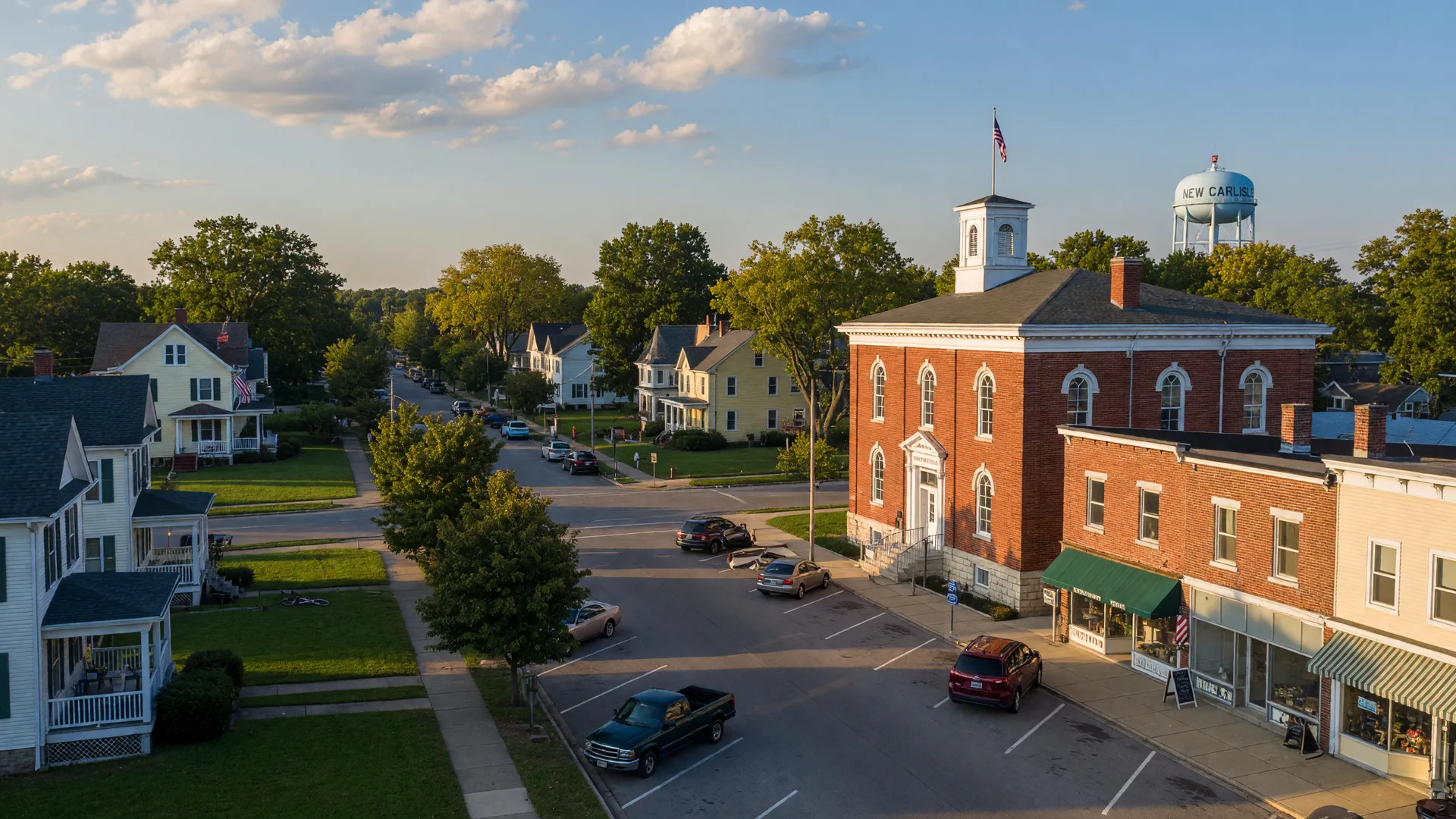 Quiet main street of New Carlisle Ohio with a brick municipal building in late afternoon light