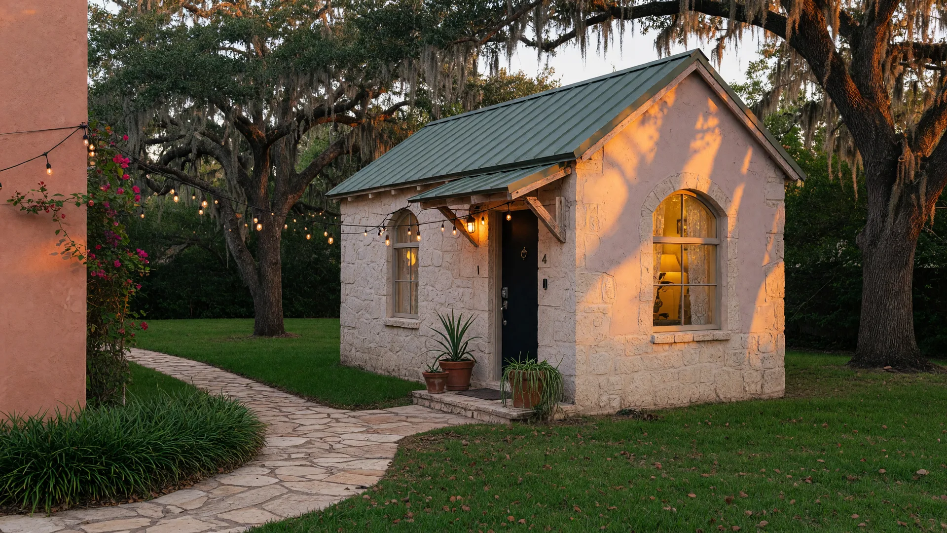 A cozy stone and stucco guest casita in a San Antonio backyard at golden hour with string lights glowing, the kind of property owners convert to a short-term rental