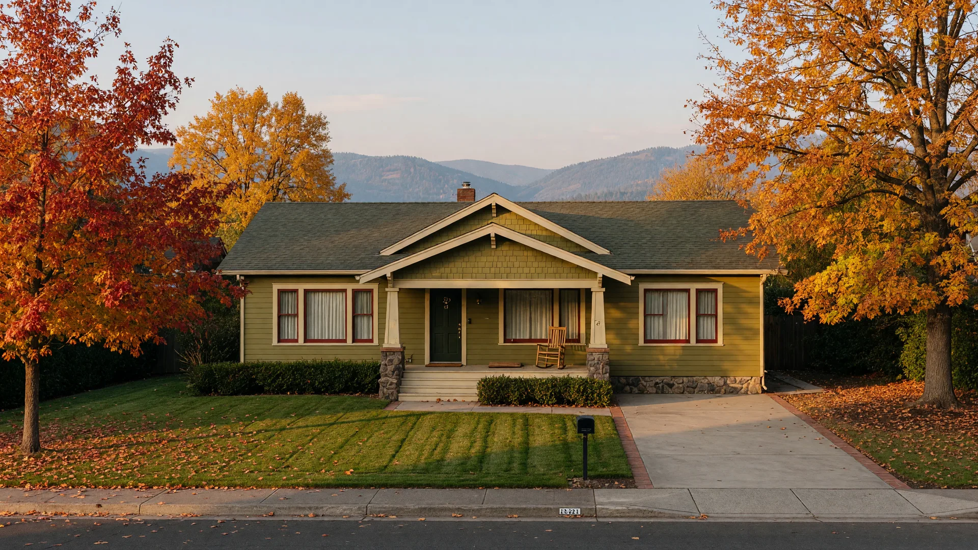 A quiet, well-maintained Southern Oregon home sitting empty on a tidy autumn lot, with golden oak trees and Rogue Valley foothills in the distance