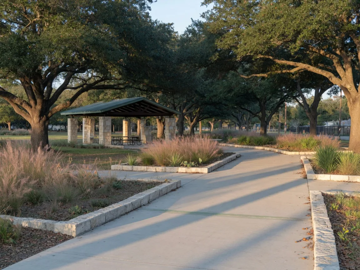 A concrete multi-use trail curving through live oaks in a north San Antonio city park
