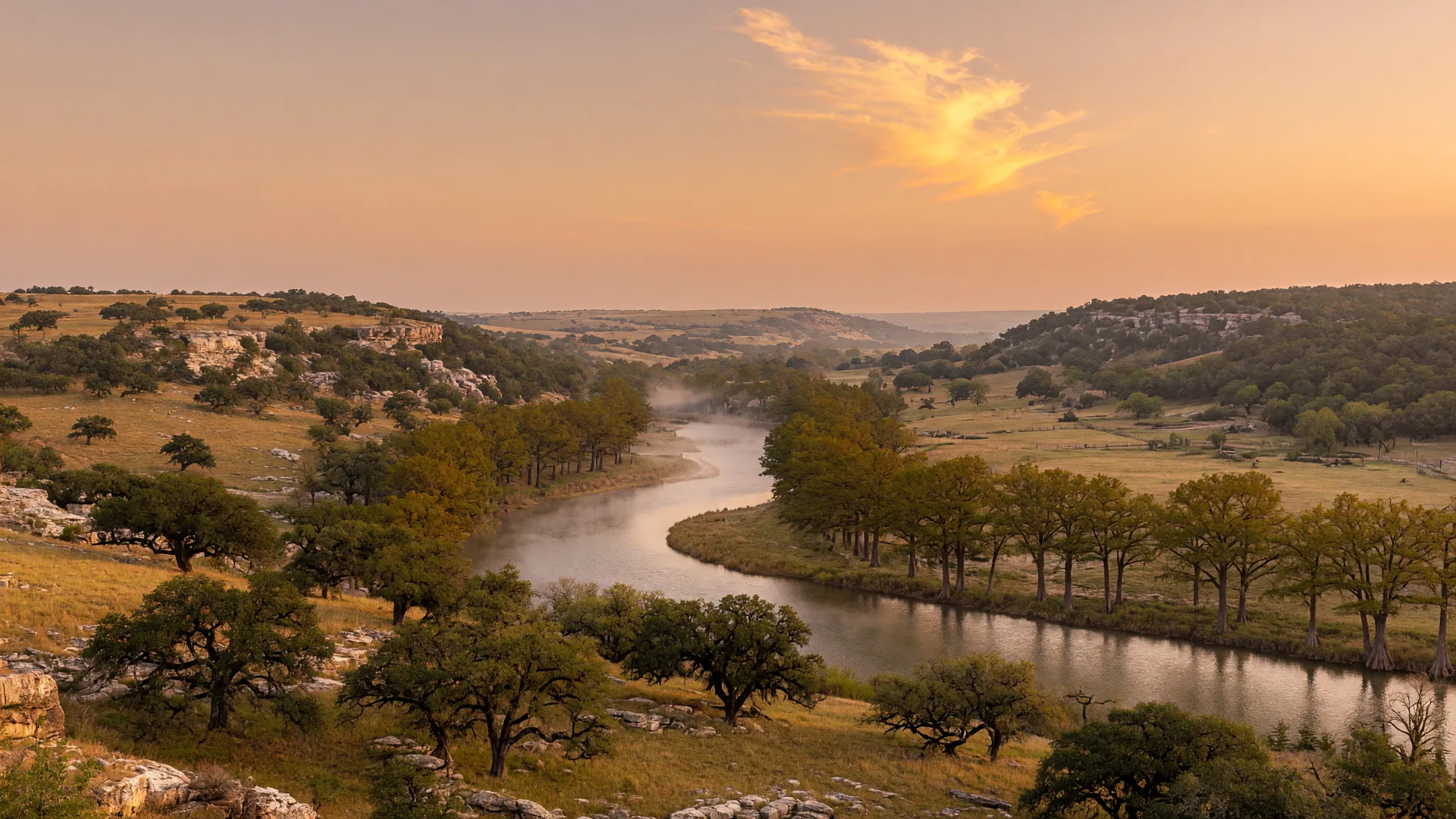 Golden-hour Texas Hill Country panorama with a winding river and cypress trees