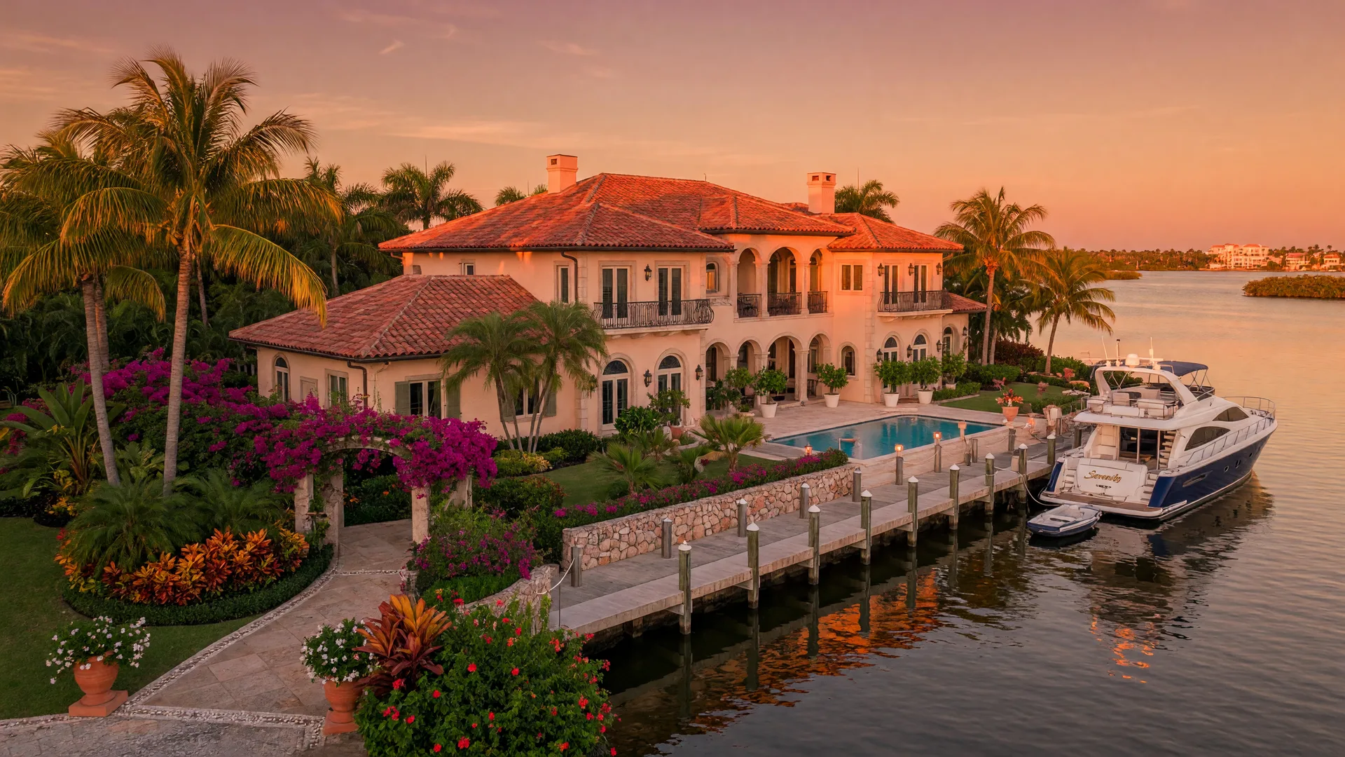 A stunning luxury waterfront estate on Sarasota Bay at golden hour with Mediterranean architecture, a private dock, and lush tropical landscaping