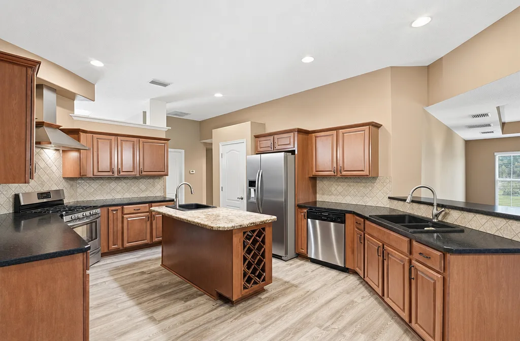 Kitchen with wood cabinetry, granite countertops, and center island