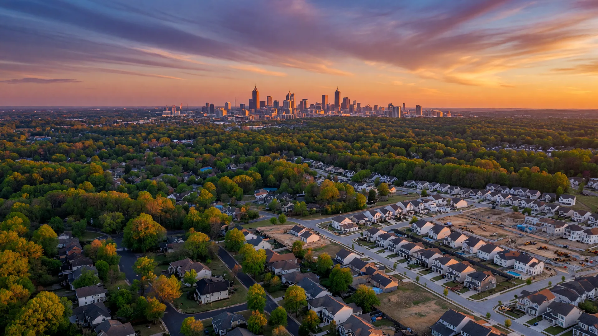 Aerial view of NW Metro Atlanta suburban neighborhoods at golden hour with the Atlanta skyline on the horizon