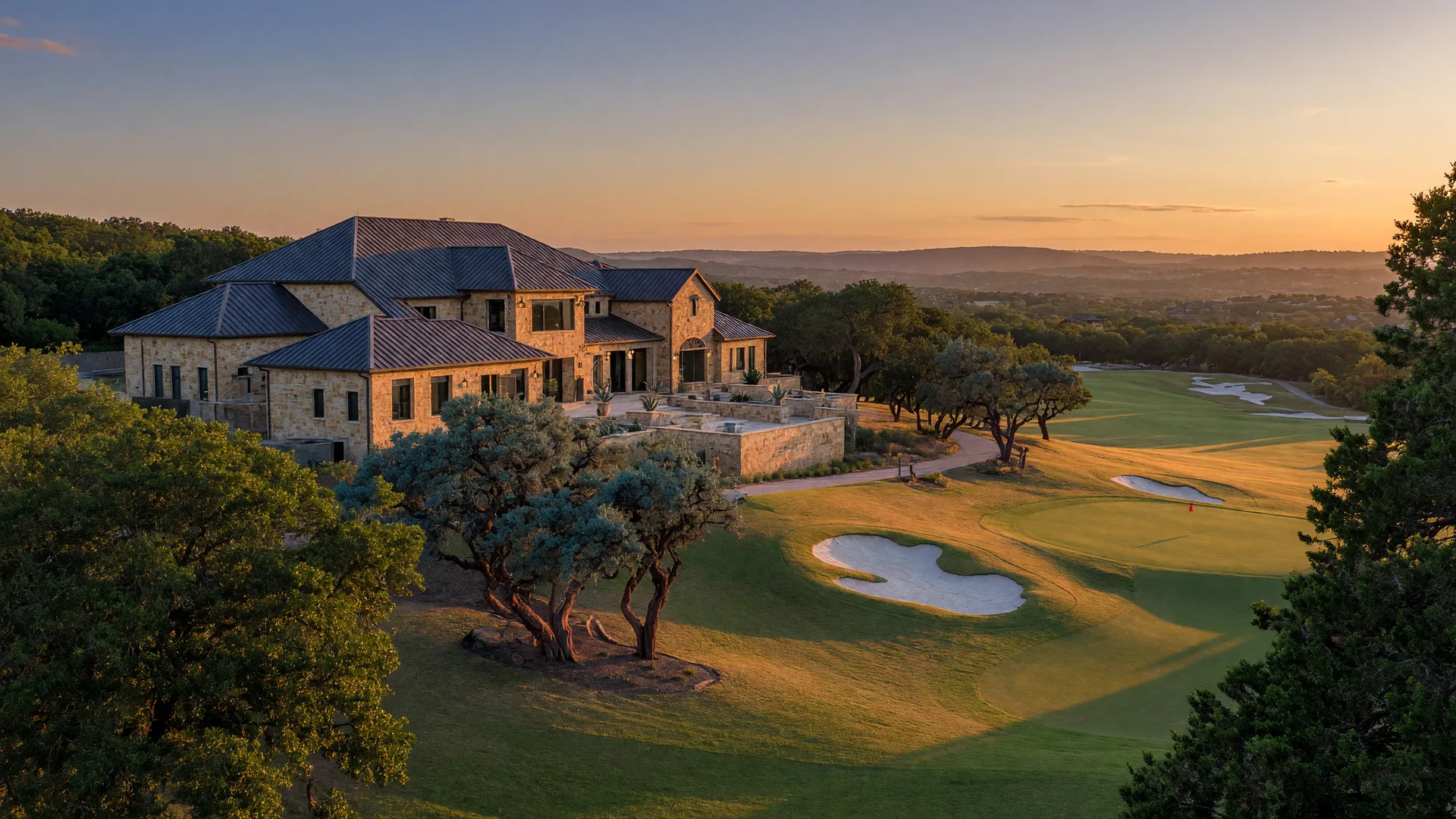 Custom Hill Country home with a golf fairway at golden hour in River Crossing, Spring Branch, Texas
