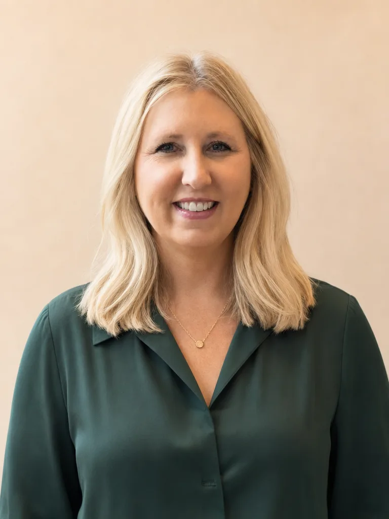 Brenda Brunner, broker with Happy Valley Home Team, in a deep green blouse with a gold necklace