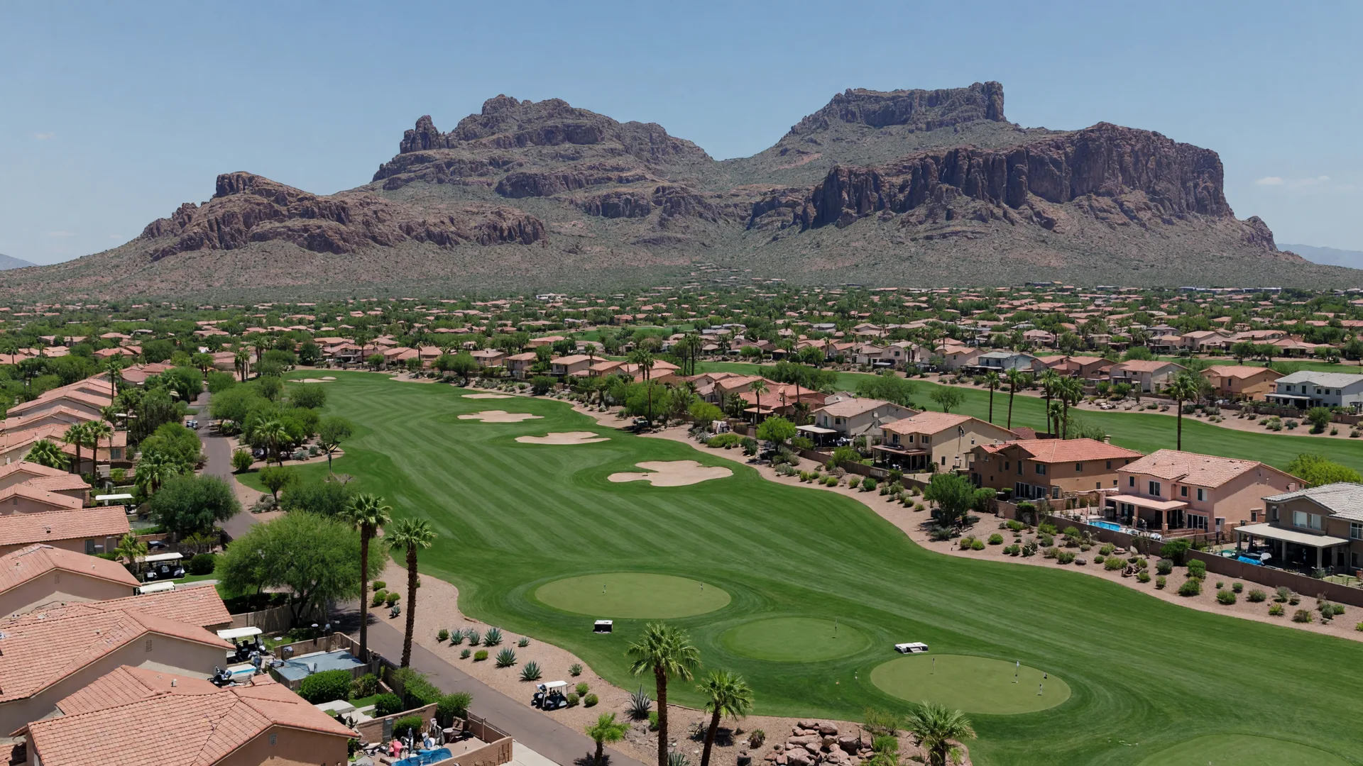 Golden hour view of Mesa, Arizona, with the Superstition Mountains on the horizon above golf and desert neighborhoods