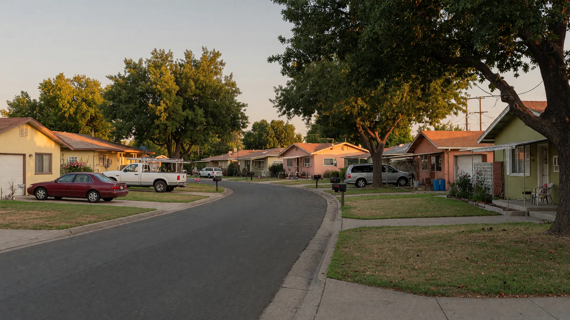 An established South Sacramento street with ranch and mid-century homes in warm evening light