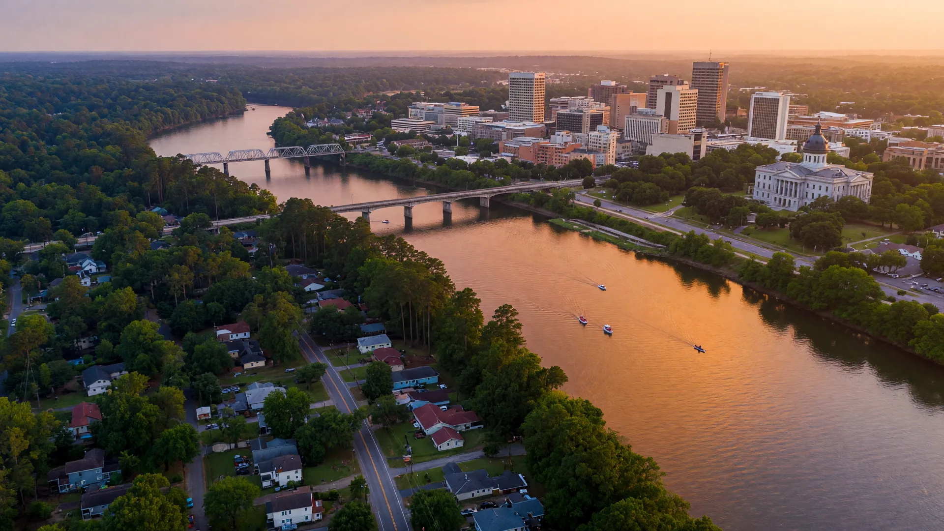Aerial view of the Columbia SC metro at golden hour, the Congaree River between the downtown skyline and Lexington County suburbs