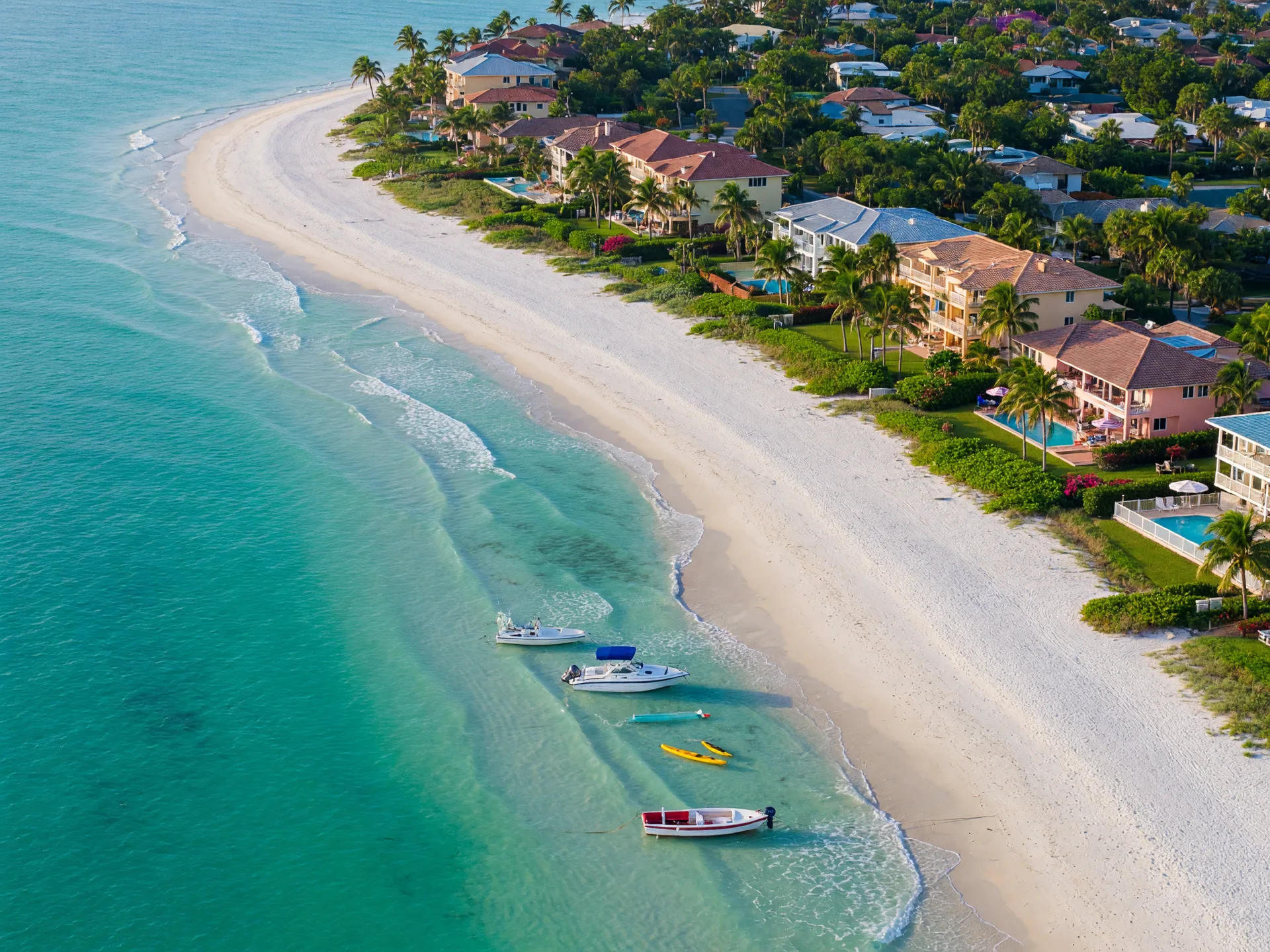 Aerial view of a white sand beach on Marco Island with turquoise water and waterfront homes