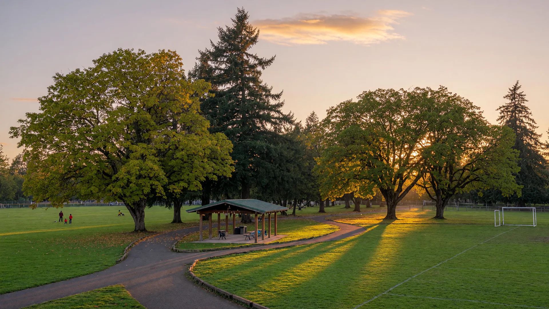 Community park with sports fields and a walking path at golden hour