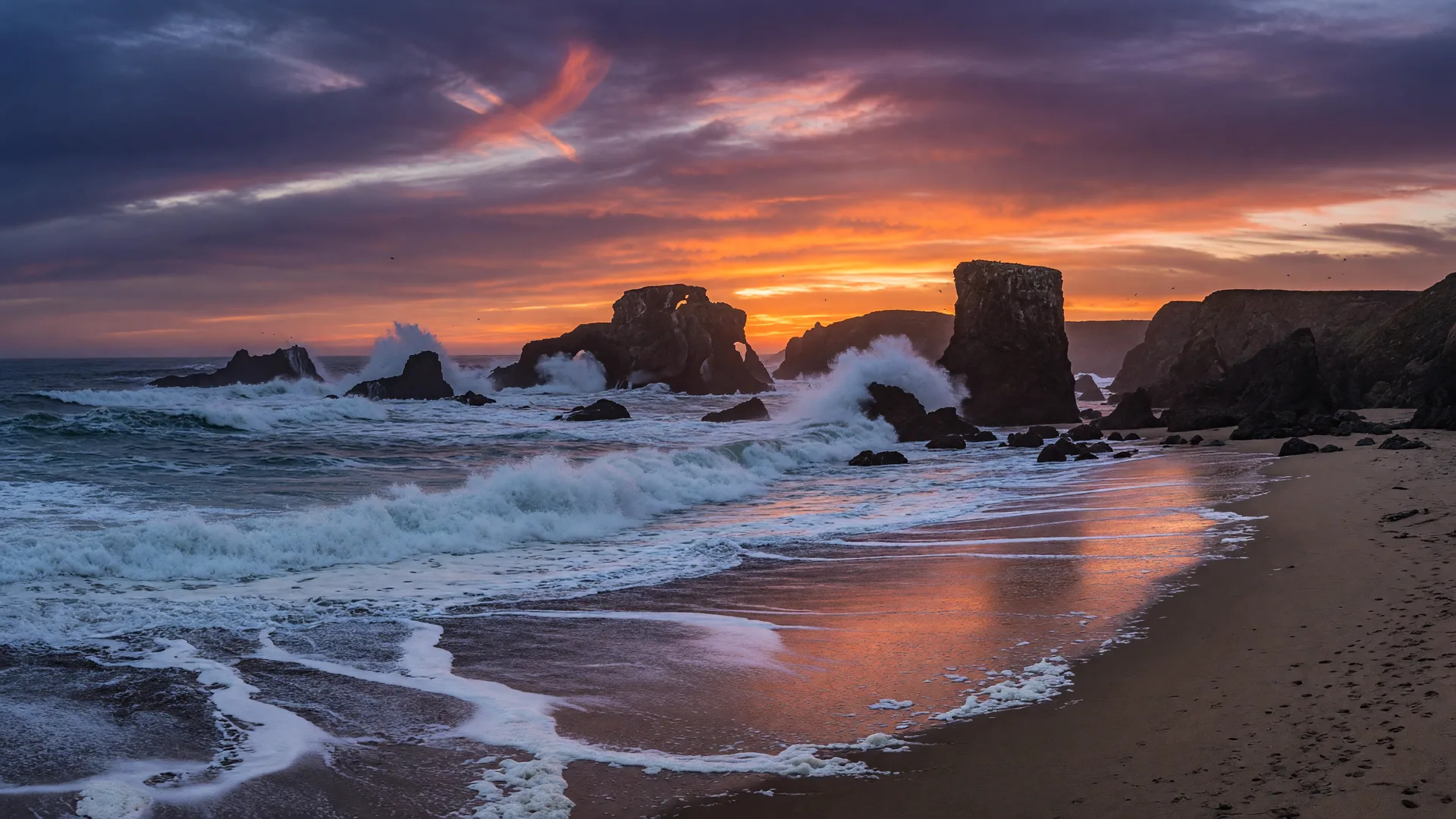 Dramatic Oregon Coast sunset with waves crashing against sea stacks