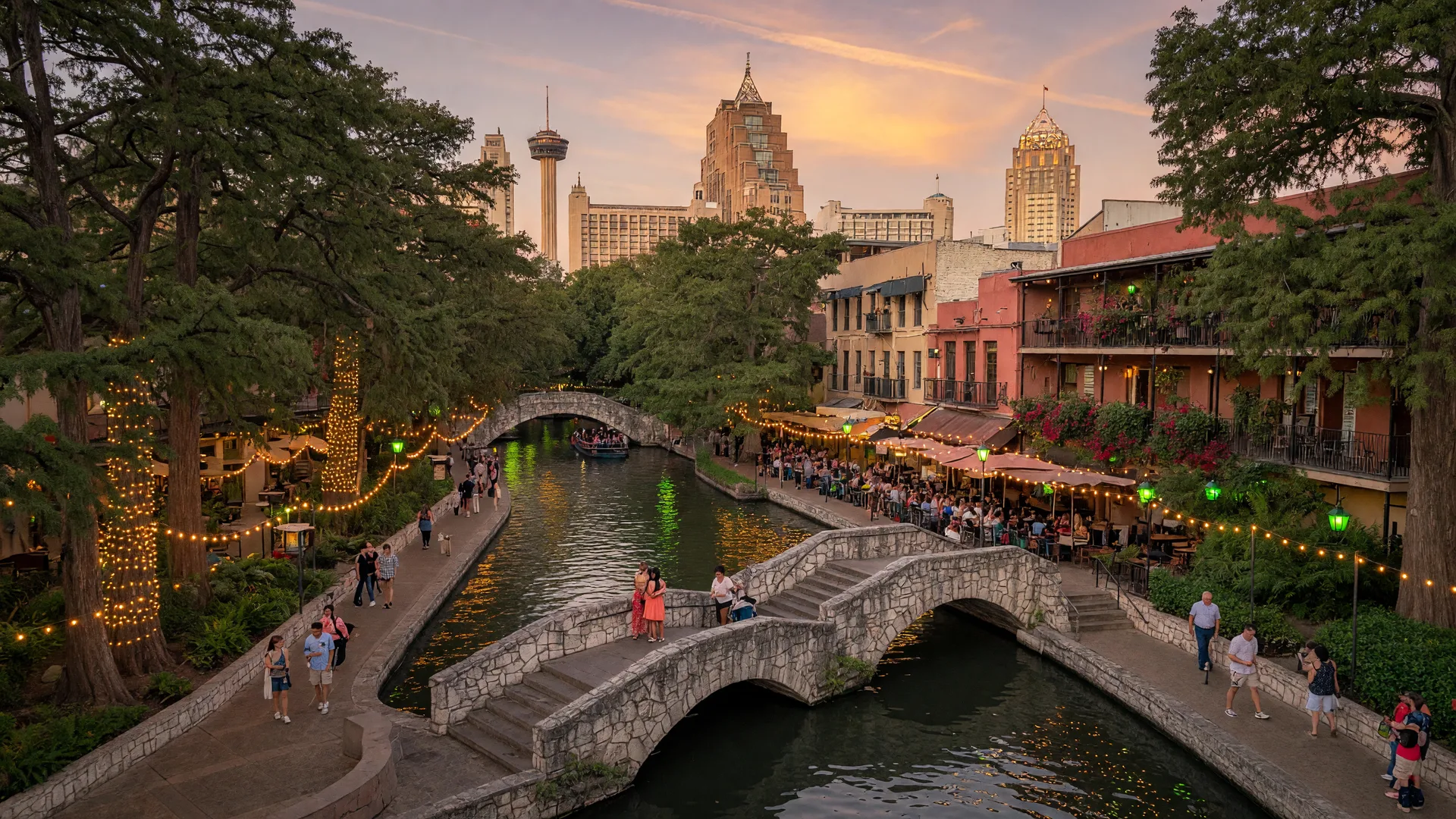 San Antonio River Walk at golden hour with cypress trees, string lights, stone bridges, and historic buildings