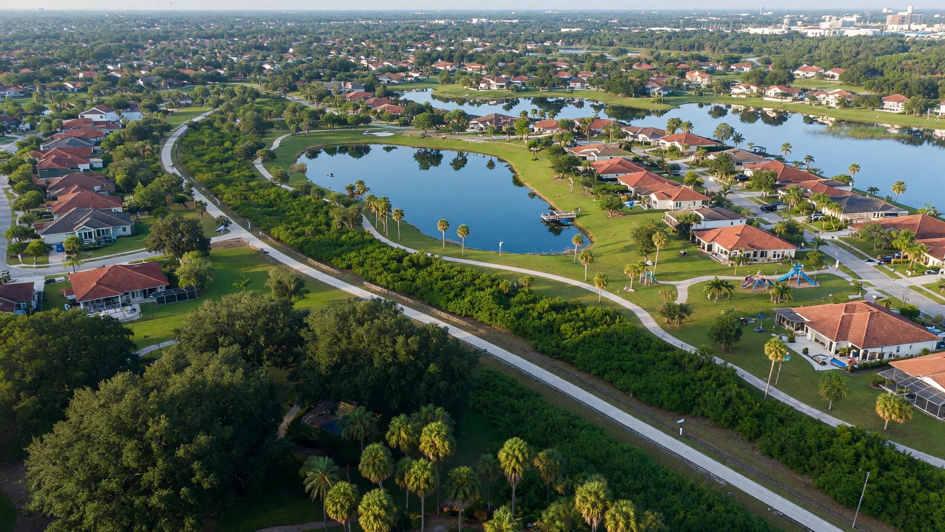 Aerial view of Palmer Ranch in south Sarasota Florida — Legacy Trail winding through lush tree canopy, lakes, parks, and established master-planned community