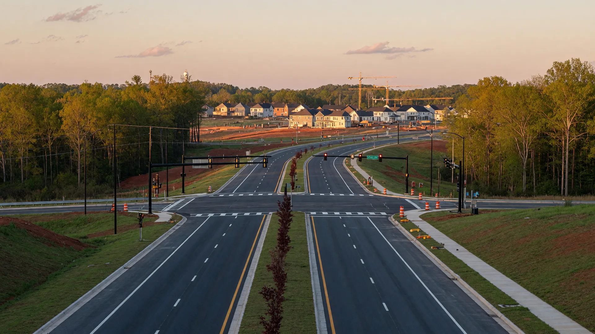 Aerial view of a new divided highway under construction through wooded North Carolina countryside