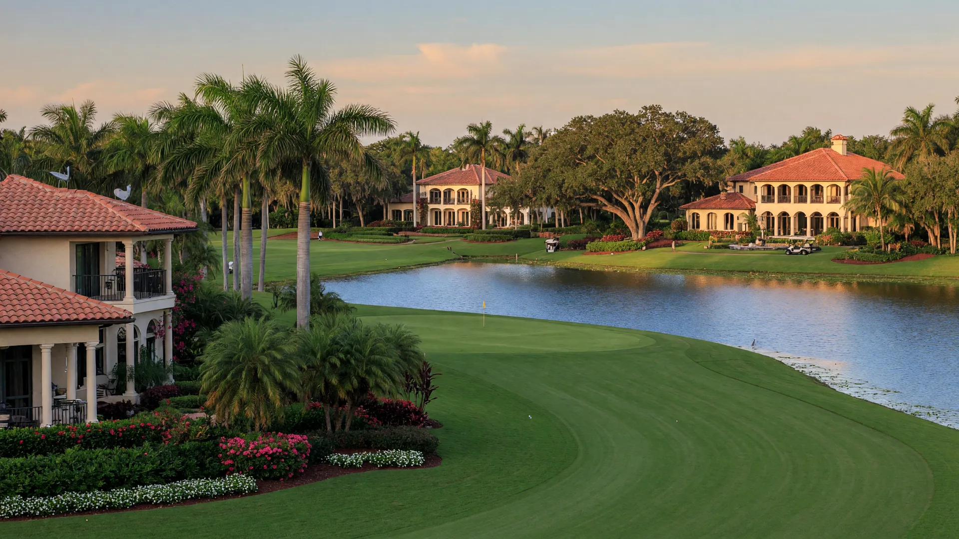 A championship golf fairway winding past a calm lake in a Boca Raton country club community, with Mediterranean-style estate homes with terracotta roofs among palm trees in golden light