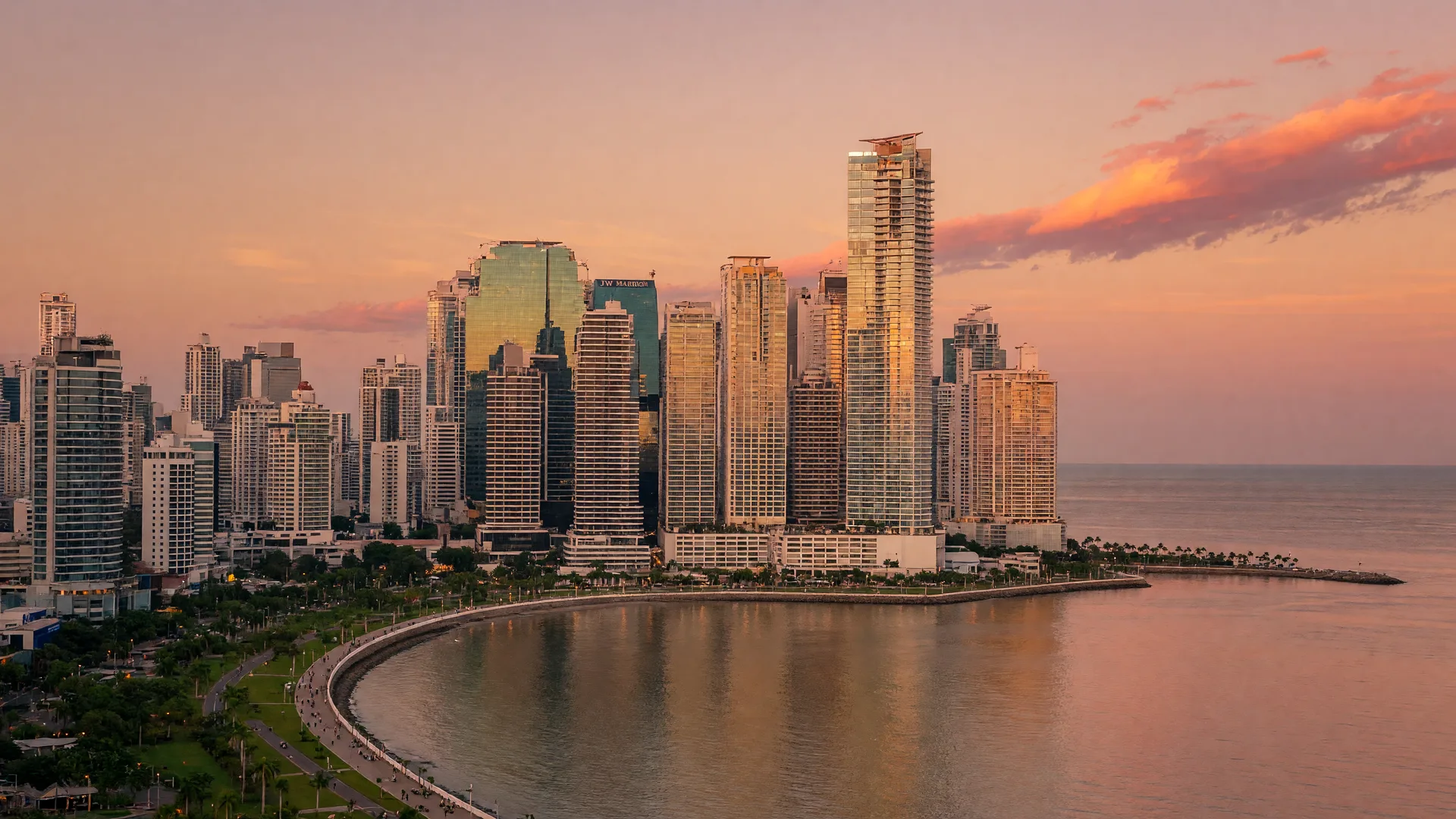 Panama City modern skyline along the Bay of Panama at golden hour, with the Cinta Costera promenade curving along the waterfront