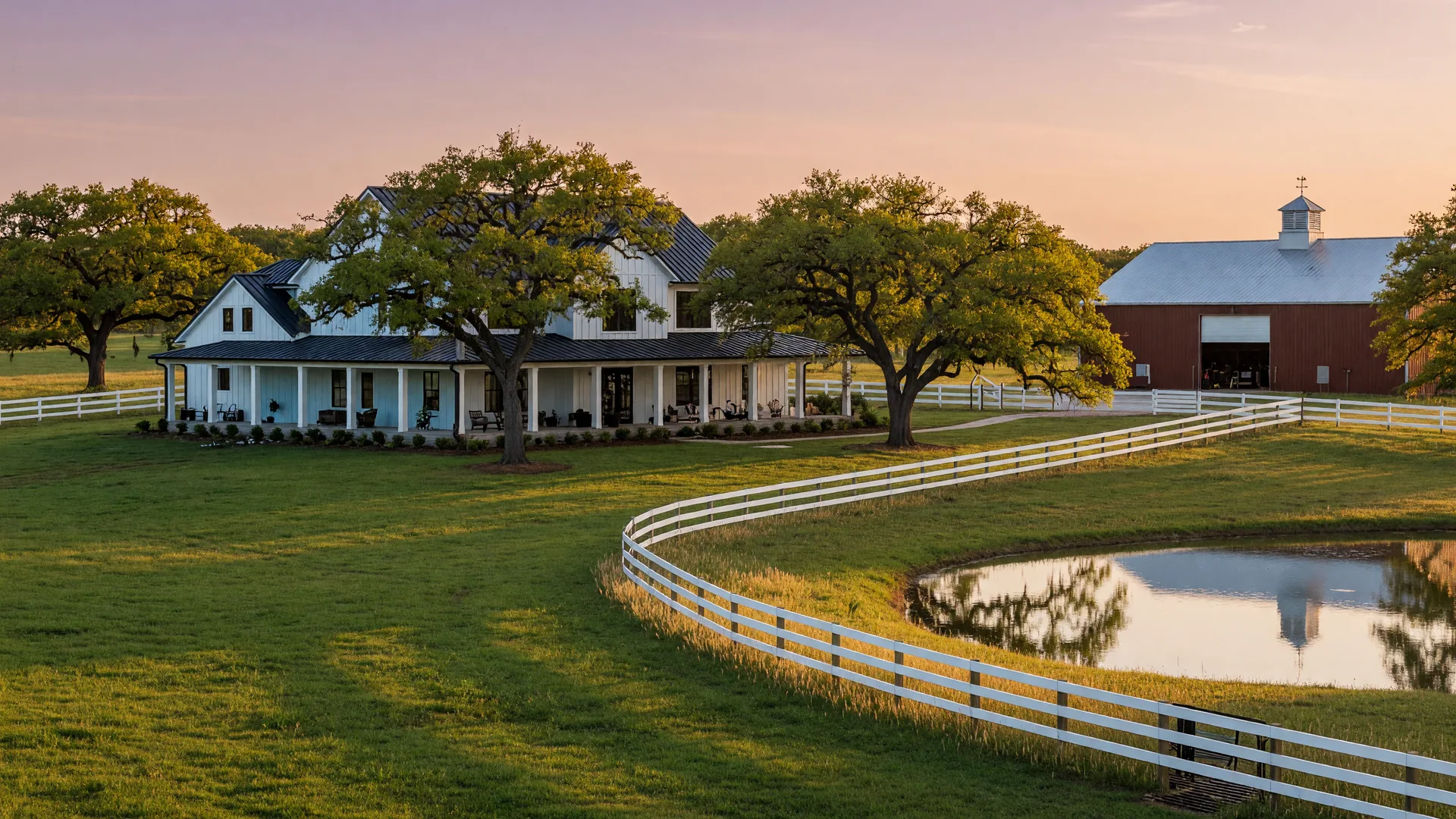 A luxury ranch estate in Northeast Texas at golden hour with a custom modern farmhouse, rolling green pastures, live oak trees, and a pond reflecting the evening sky