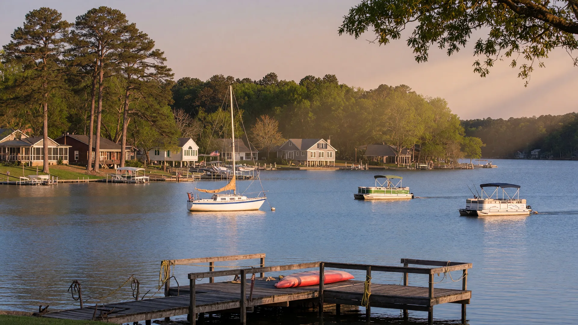 Serene Lake Wylie SC with waterfront homes, docks, sailboats, and forested shoreline at golden hour