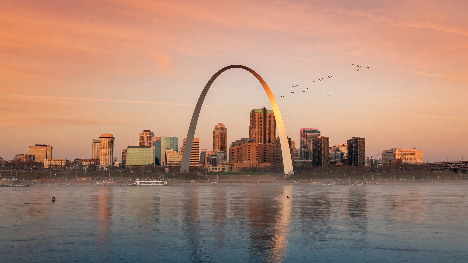St. Louis skyline with the Gateway Arch at golden hour, reflected in the Mississippi River