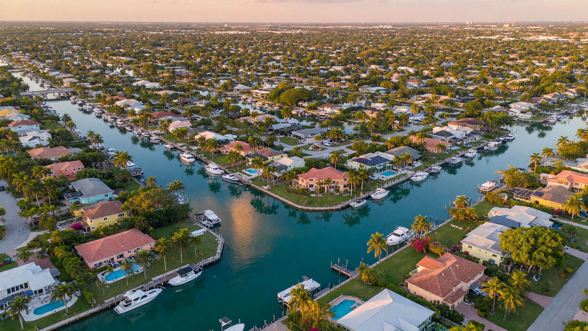 Aerial view of Cape Coral canals and neighborhoods under golden Florida sunshine
