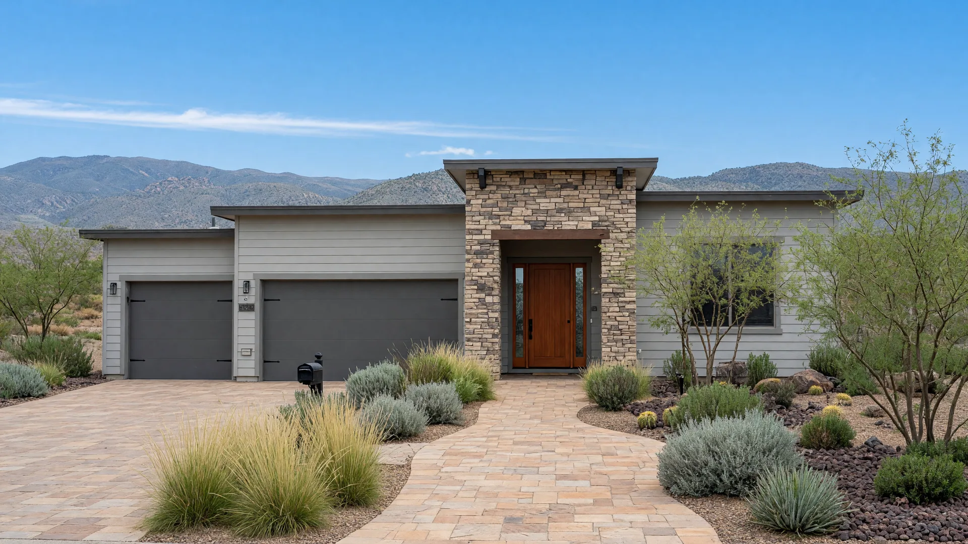 A modern Carson City home with stone accents and fresh landscaping under a bright high-desert sky, with the Sierra foothills behind.