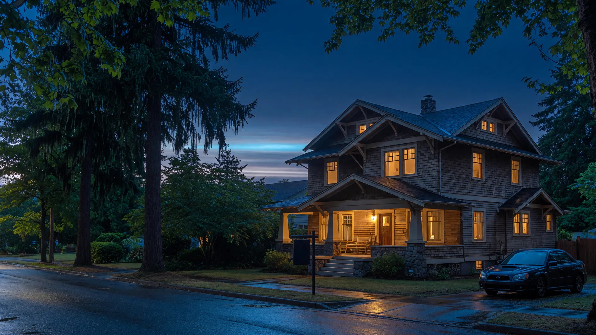 A craftsman home in a quiet Portland suburb at blue hour, warm windows glowing against a deep navy sky