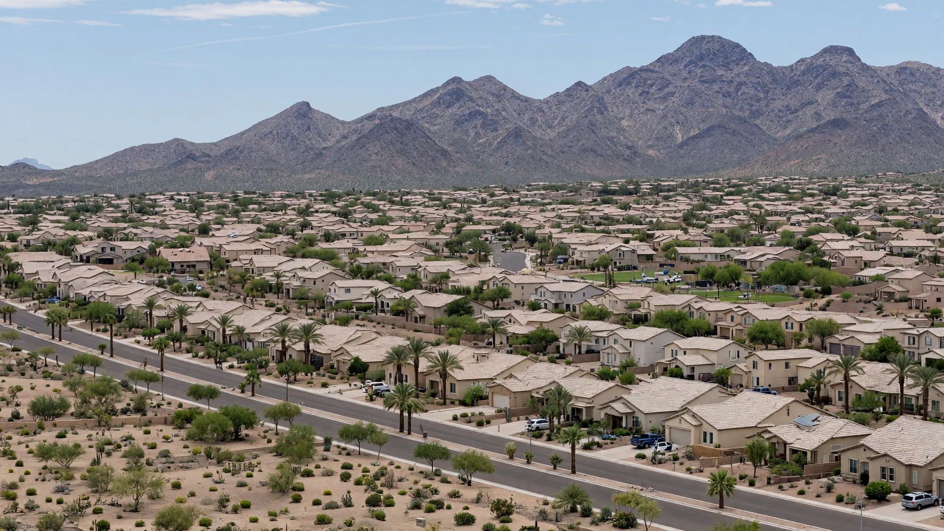 Golden hour aerial view of Avondale, Arizona, with master-planned neighborhoods, the I-10 corridor, and the Sierra Estrella mountains on the horizon