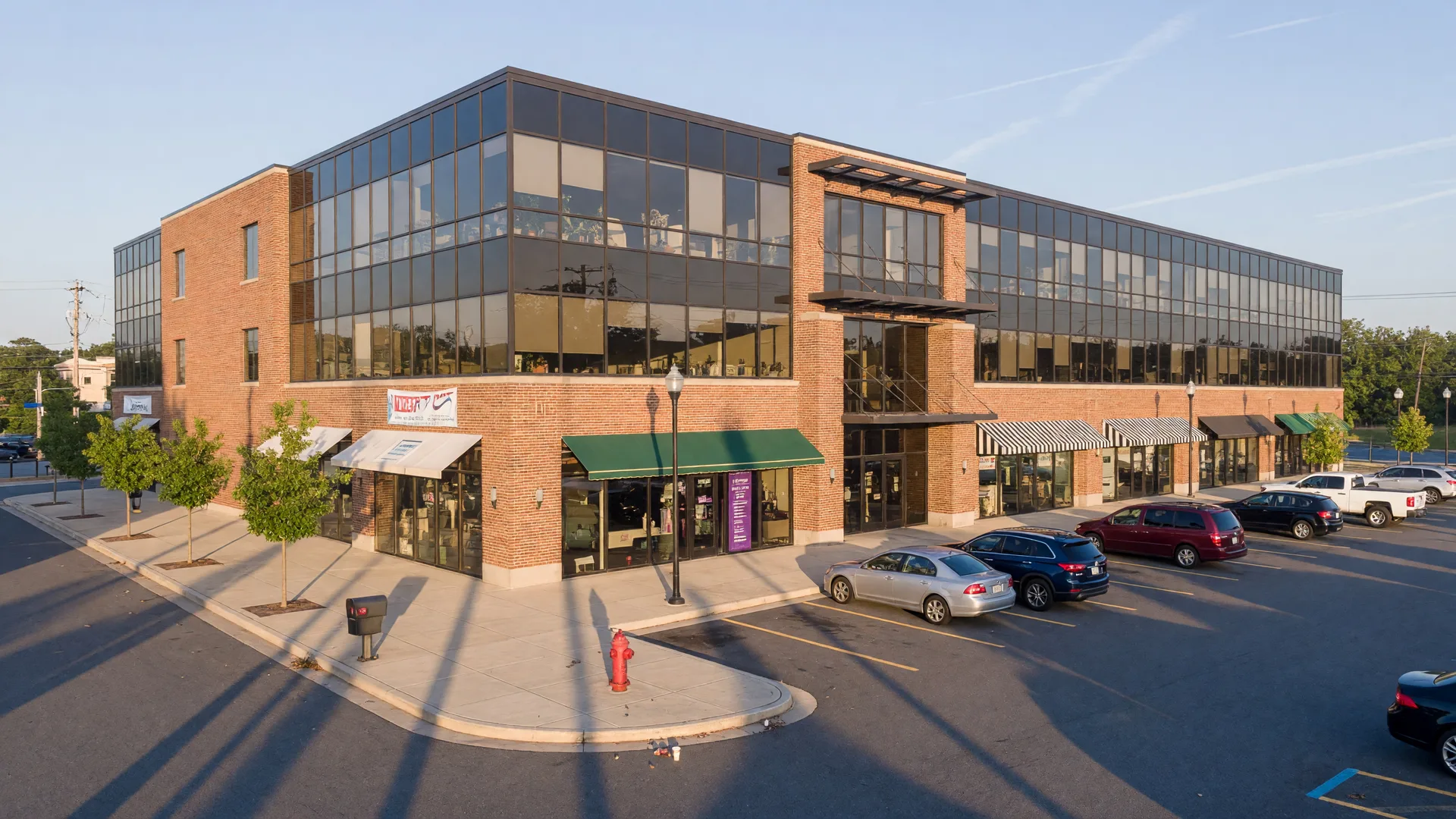 Multi-tenant commercial building in a Maryland suburb, well-maintained brick and glass facade under morning light